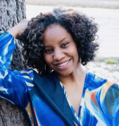 Black woman in blue shirt smiles 