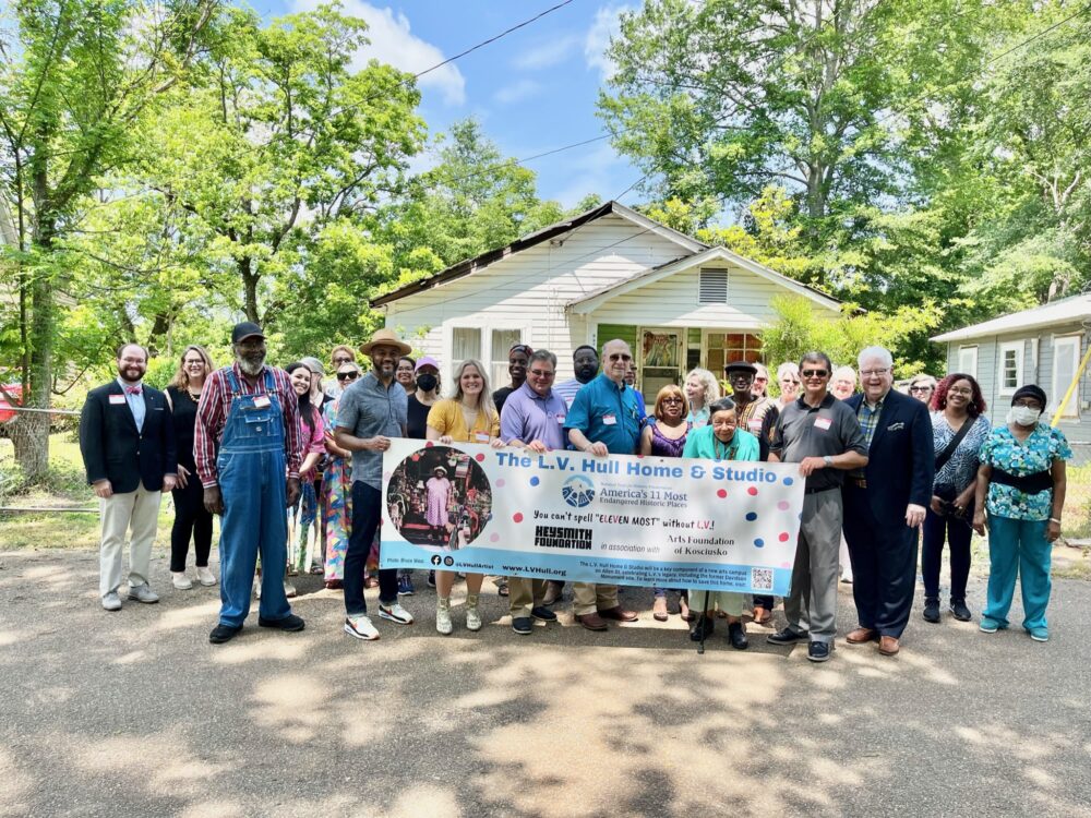 People gathered with a banner in front of L.V. Hull's house