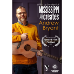 Andrew Bryant holds a guitar