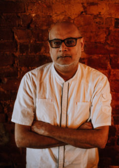 Vinh stands in front of a brick wall