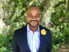 Yaphel Smith wears a jacket with a yellow flower in the lapel